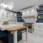Blue and white kitchen with marble island and crystal chandeliers