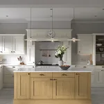 Cream shaker kitchen with oak island, white worktop and pendant lighting
