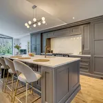 Dark grey in frame kitchen with long island and upholstered bar stools