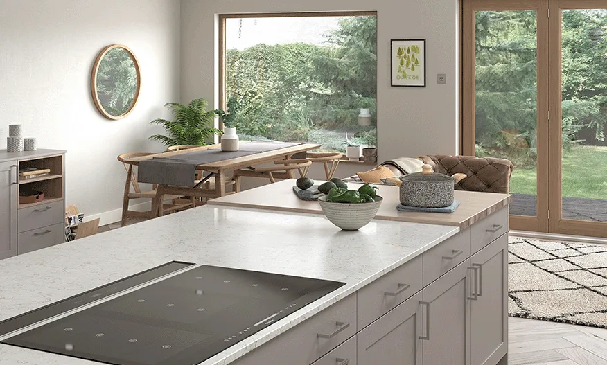 Light grey kitchen island with induction hob set into quartz worktop