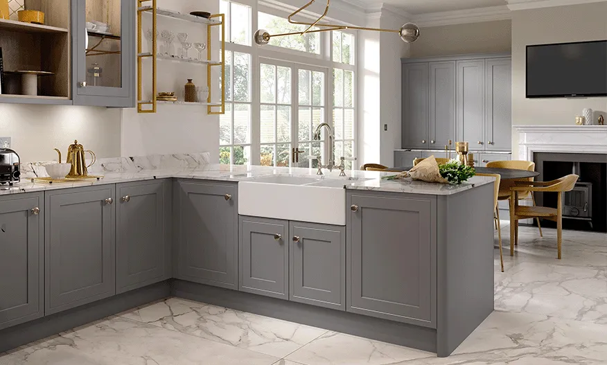 Grey shaker kitchen with white Belfast sink, marble worktop and brass pendant light
