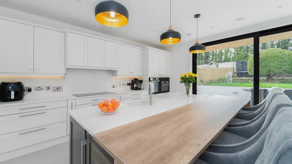Kitchen island with oak breakfast bar and black gold pendant lights