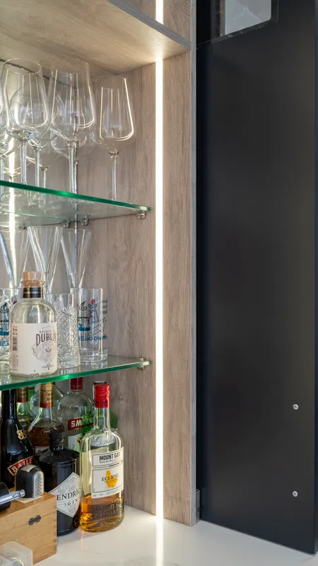 LED strip lighting inside oak effect bar cabinet with glass shelves
