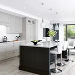 Light grey shaker kitchen with dark charcoal island and glass pendant lights