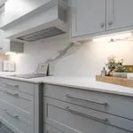 Light grey shaker kitchen with induction hob and marble splashback