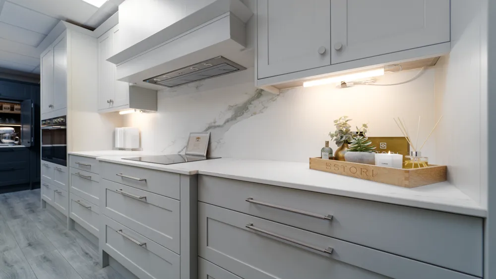 Light grey shaker kitchen with induction hob and marble splashback