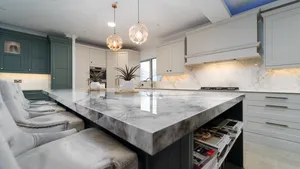 Marble effect quartz island with grey velvet stools and pendant lights