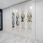 Mirrored cross lattice wardrobes beside smoked glass sliding doors