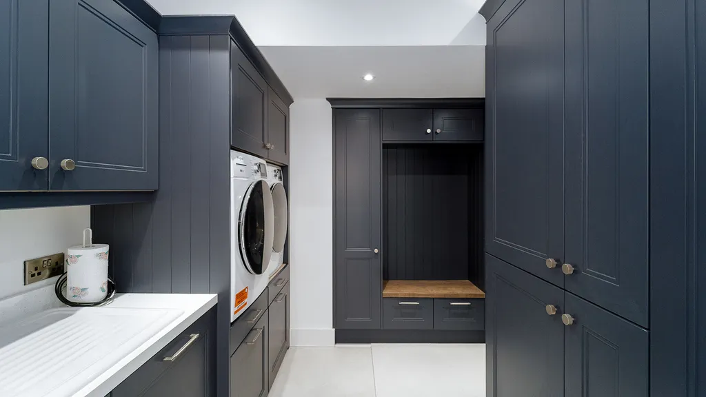 Navy boot room with bench seat, shoe storage and laundry appliances