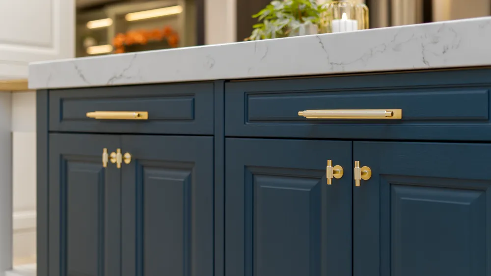 Navy blue cabinet doors with brass handles under marble worktop