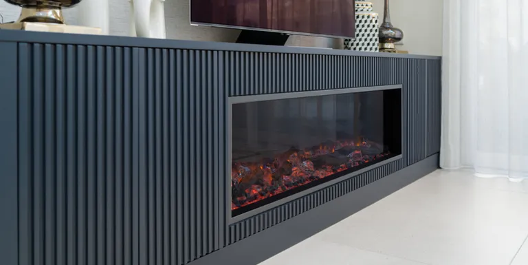 Navy fluted media unit with built-in electric fireplace below the television