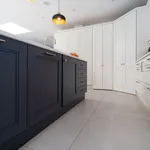 Low angle view along navy island facing white shaker cabinets