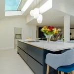 Navy blue kitchen island with white quartz top and blue bar stools