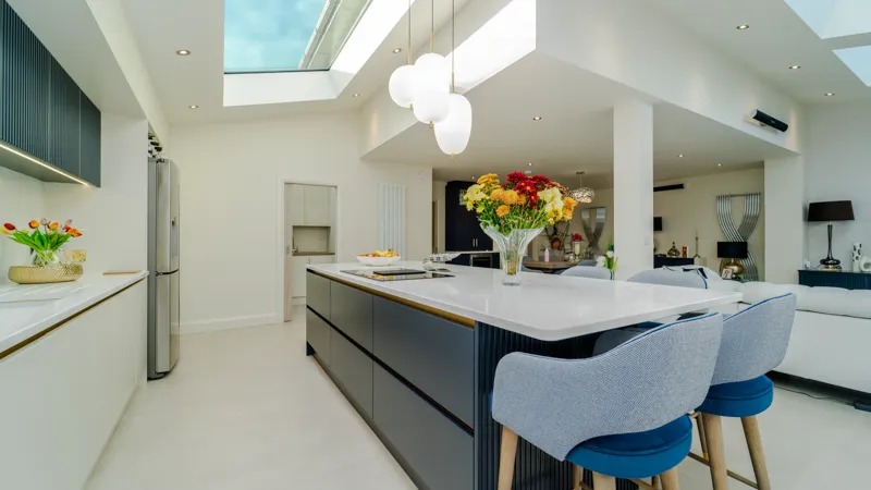 Navy blue kitchen island with white quartz top and blue bar stools
