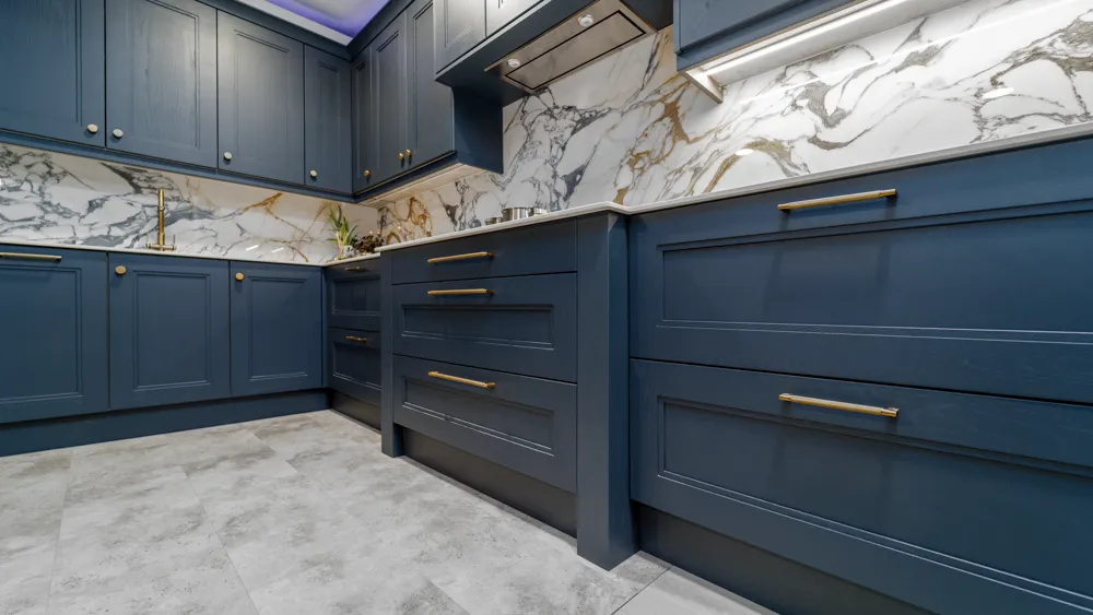 Navy shaker kitchen with gold veined marble splashback and brass handles