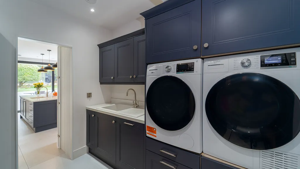 Navy utility room with built in washing machine and tumble dryer