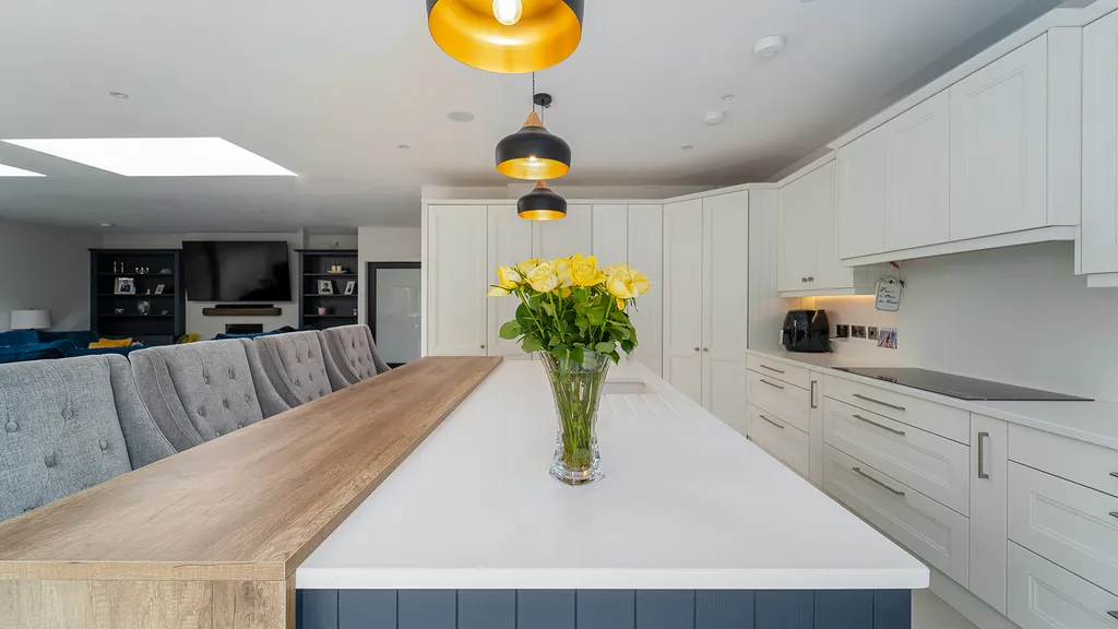 Open plan kitchen island with yellow roses and oak breakfast bar