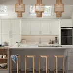 Pale sage kitchen with rattan pendant lights, skylights and breakfast bar stools