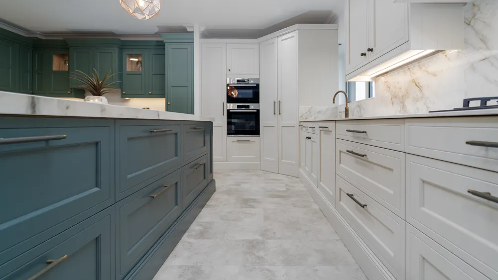 Two tone kitchen with teal island, green and cream cabinets
