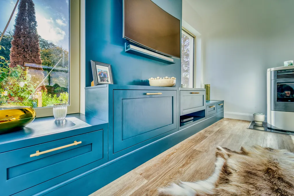 Close view of teal TV cabinets with brass bar handles
