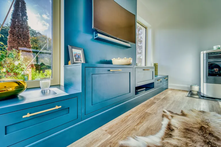Close view of teal TV cabinets with brass bar handles
