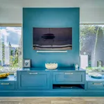 Symmetrical view of teal media wall with centred television