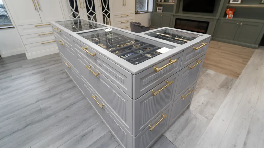 Grey dressing room island with glass top jewellery display drawers