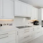 White kitchen run with induction hob and integrated double ovens