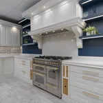 White panelled kitchen corner with stone splashback and range cooker