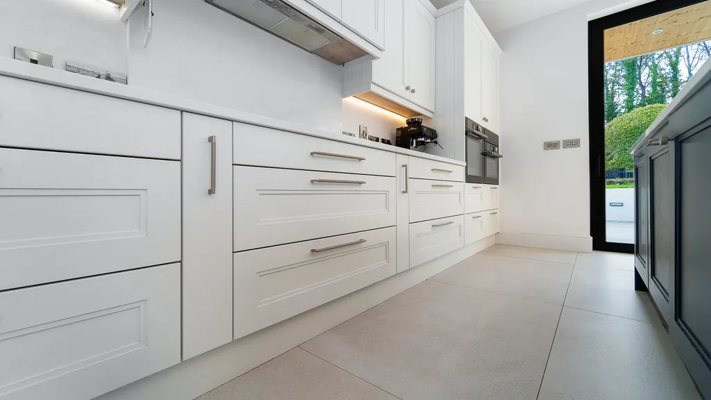 White shaker kitchen drawers with steel handles and cooker hood