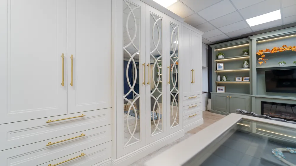 White wardrobes with mirrored doors, drawers and brass handles